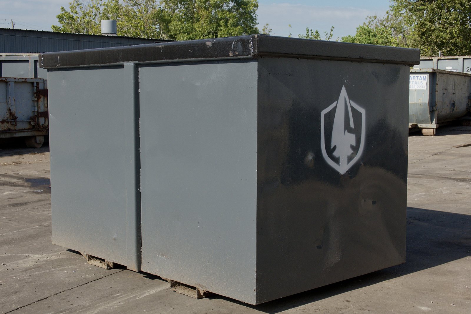 Two Spartan Metals steel bins with the shield logo